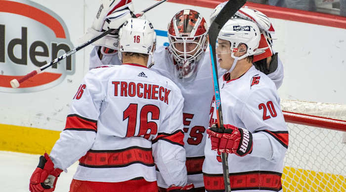 Carolina Hurricanes Vincent Trocheck (16), Antti Raanta (32) and Sebastian Aho (20) celebrate a victory after an NHL hockey game against the Pittsburgh Penguins, Sunday, Feb. 20, 2022, in Pittsburgh.